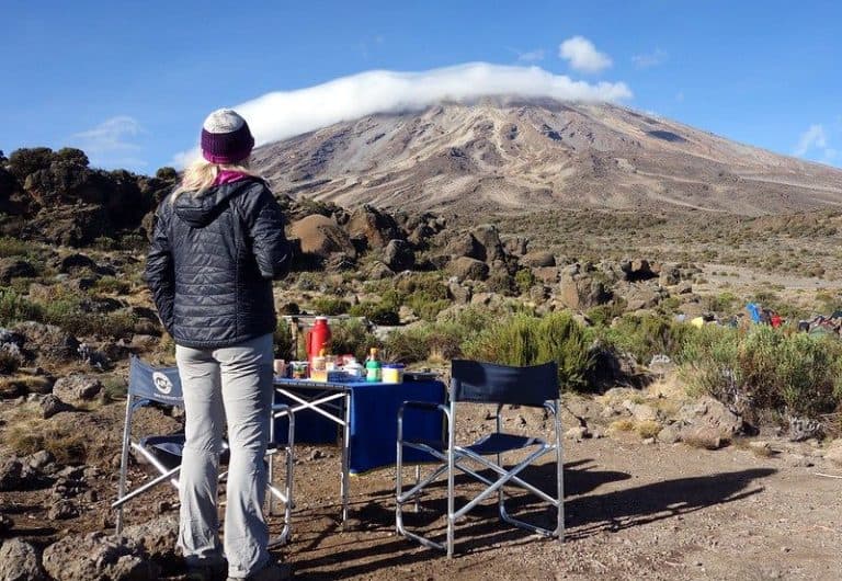 Trekkers enjoying a rest stop with a view of Mount Kilimanjaro