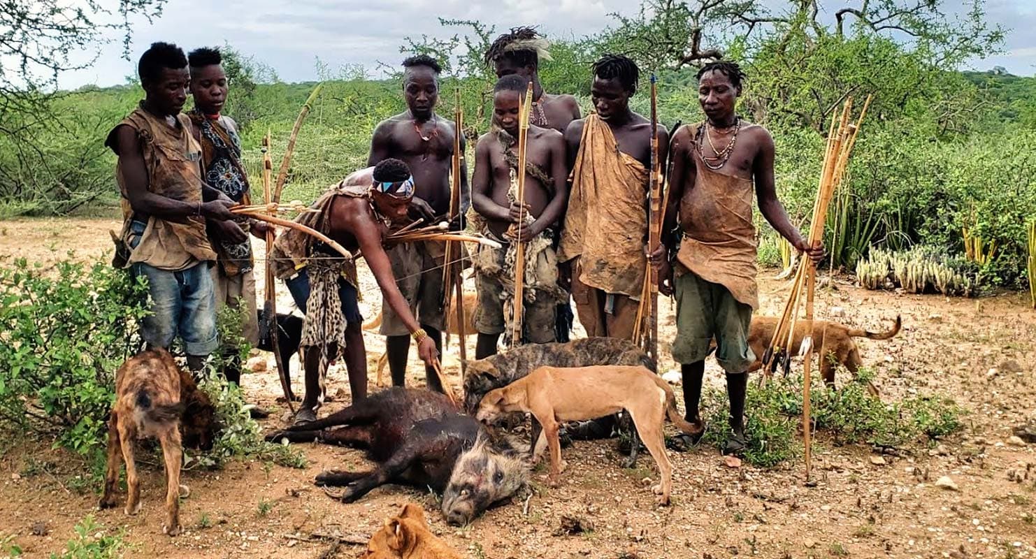 Hadzabe tribespeople with traditional bows on a hunting expedition