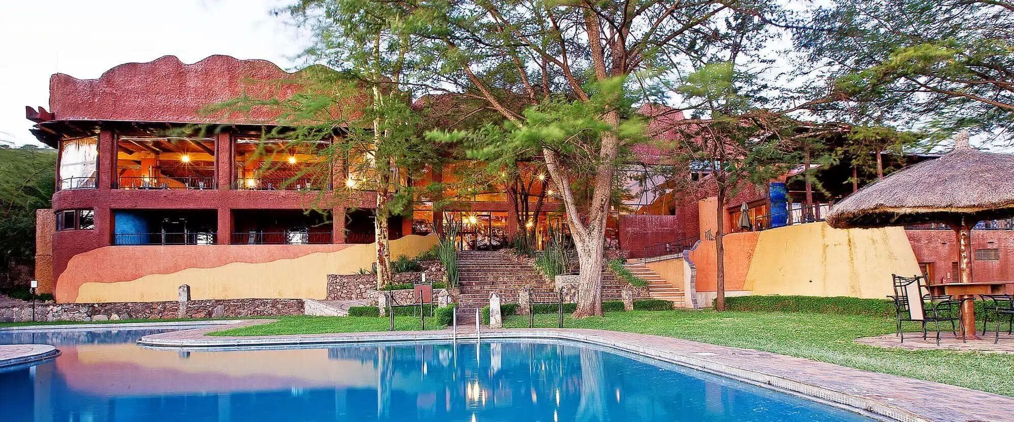Lodge fascia media con piscina e giardini lussureggianti al crepuscolo