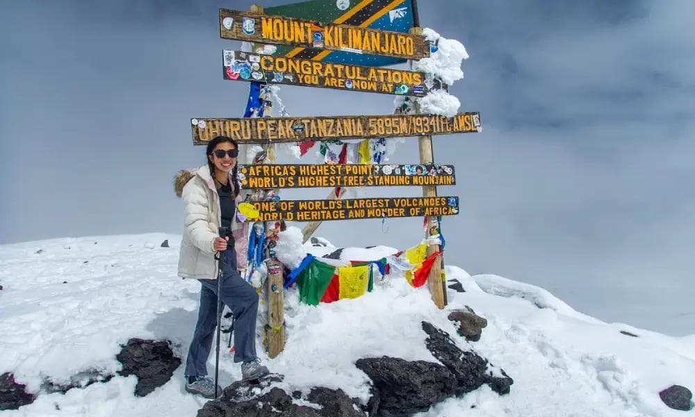 Climber at the Uhuru Peak summit sign